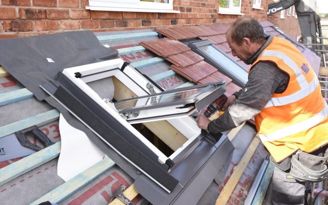 A house builder installing a window
